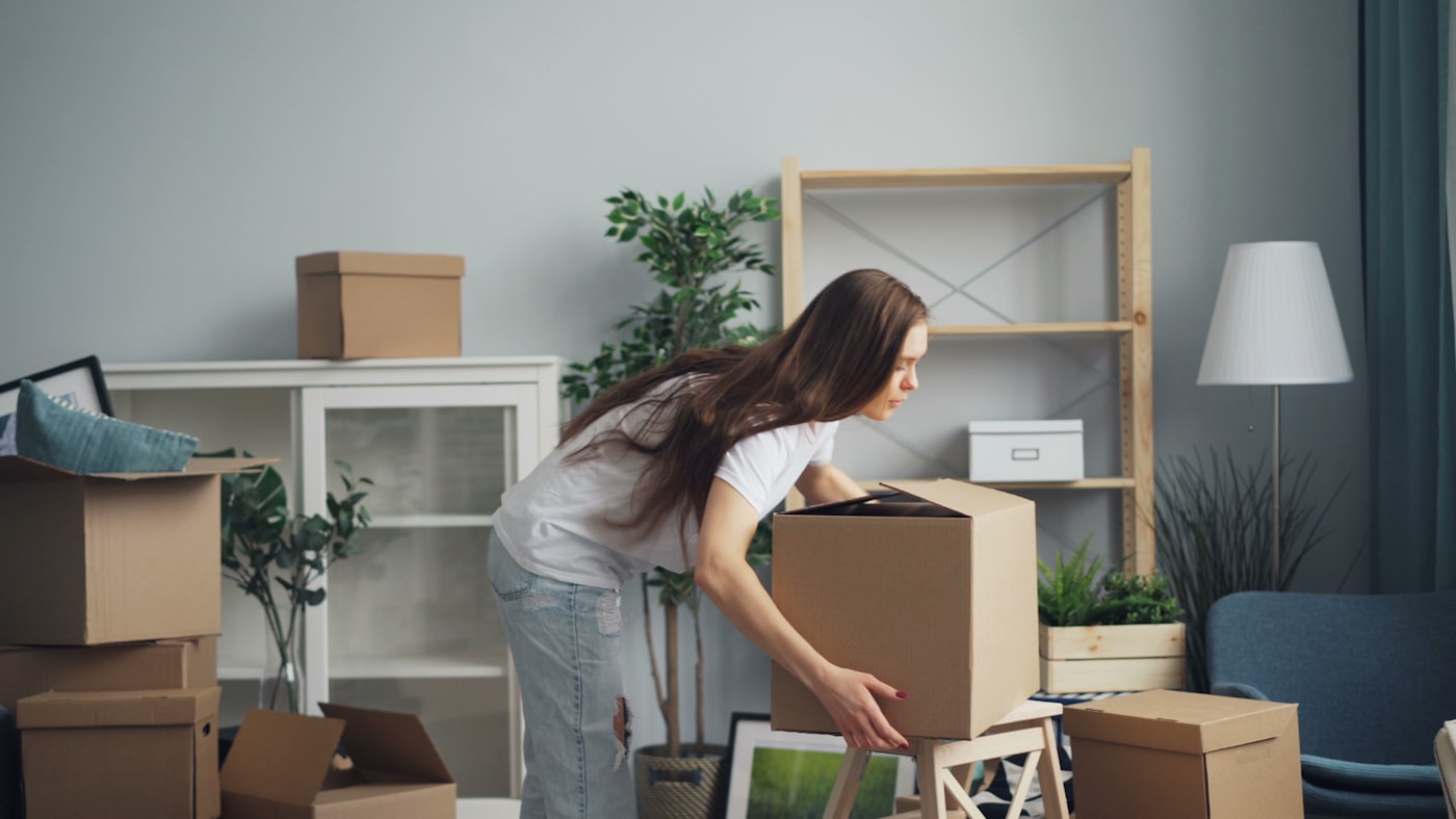 A room mid-move with labeled moving boxes being carefully packed